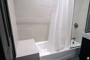 Full bathroom featuring shower / bath combination with curtain and vanity
