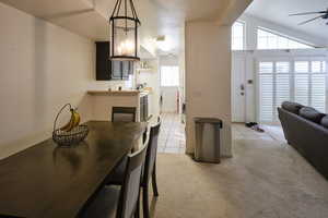 Dining room with light carpet, ceiling fan, and light tile patterned floors