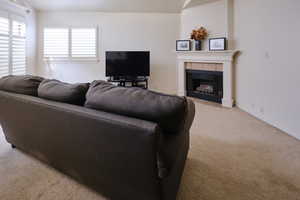 Living room with light colored carpet and a tile fireplace
