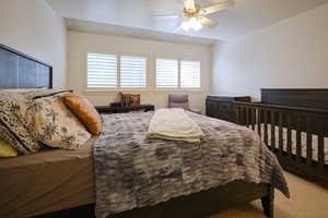 Carpeted bedroom with ceiling fan