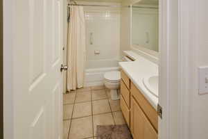Bathroom featuring vanity, light tile patterned floors, and shower / bathtub combination with curtain