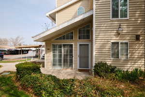 View of property exterior with a carport and a patio