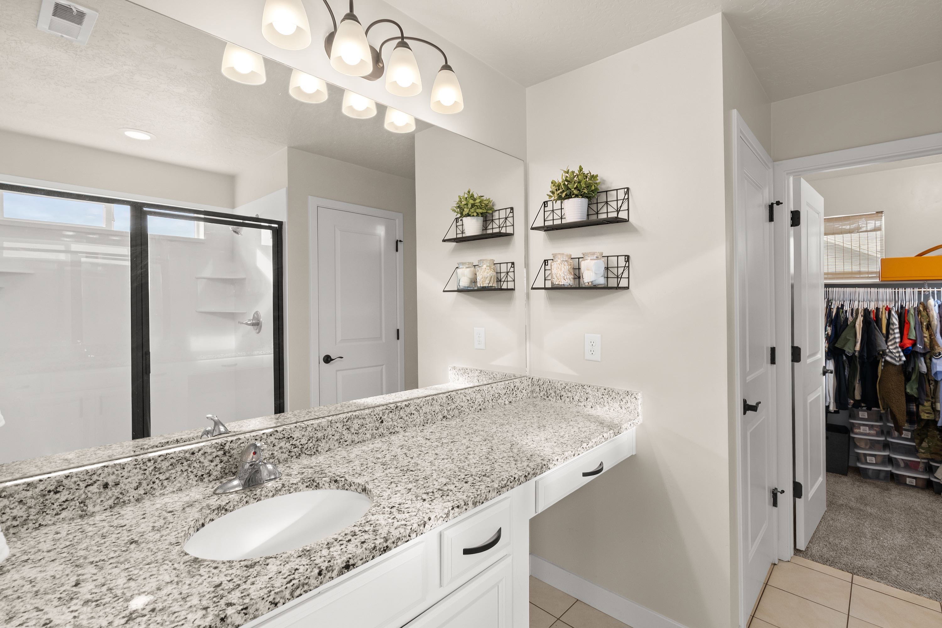 Bathroom with vanity, a shower stall,  closet, and light colored carpet