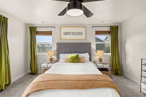 Bedroom with light colored carpet, a ceiling fan, and a textured ceiling