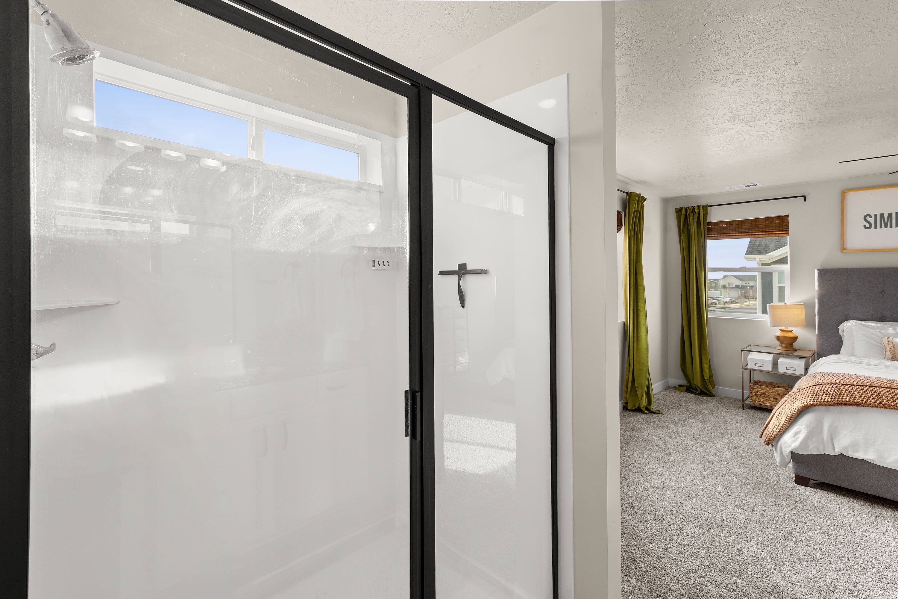 Ensuite bathroom featuring tile floors, a shower stall, and a textured ceiling