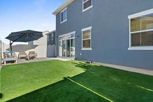 Rear view of house featuring stucco siding, a patio, and outdoor lounge area