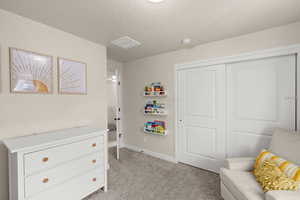 Sitting room with a textured ceiling and light colored carpet