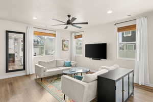 Living area featuring plenty of natural light, light wood-style flooring, ceiling fan, a textured ceiling, and recessed lighting