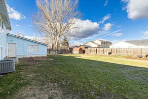 Fenced backyard with a residential view and a storage shed