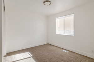Carpeted empty room with baseboards