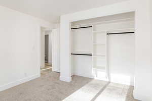 Unfurnished bedroom featuring light colored carpet and a closet