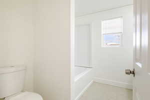 Bathroom featuring light tile patterned floors and a tub