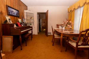 Dining space featuring light colored carpet and a textured ceiling