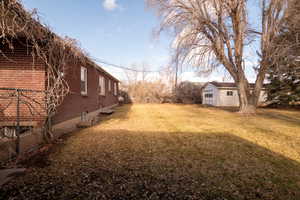 View of grassy yard featuring an outbuilding