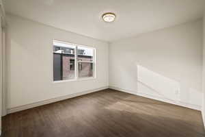 Unfurnished room featuring wood finished floors and a textured ceiling
