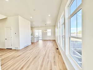 Unfurnished living room featuring a chandelier, recessed lighting, and light wood-style floors