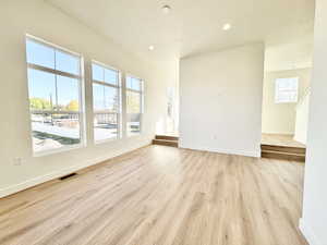 Spare room with light wood-style floors, a textured ceiling, and recessed lighting