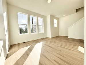 Unfurnished living room with light wood-style floors and baseboards