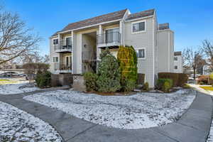 Snow covered property featuring a view of apartment building / complex