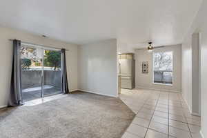 Living room featuring  plenty of natural light, light tile patterned floors, and light colored carpet