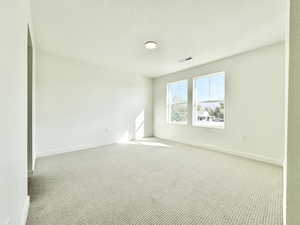 Empty room featuring carpet floors and a textured ceiling