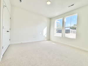 Spare room with light colored carpet and a textured ceiling