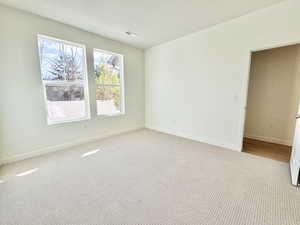 Unfurnished room featuring a textured ceiling and carpet floors