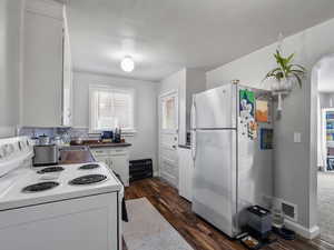 #37 (Upstairs 2-bedroom): Kitchen with white appliances, white cabinets, dark wood finished floors, and arched walkways