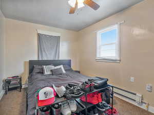 #31 (Upstairs 1-bedroom): Bedroom with carpet, ceiling fan, and a baseboard heating unit