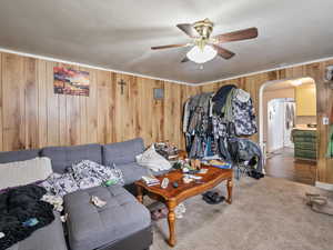 #39 (Basement 1-bedroom): Carpeted living room with wood paneling walls, and ceiling fan