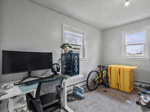 #37 (Upstairs 2-bedroom): Carpeted bedroom #2, office space with a baseboard heating unit