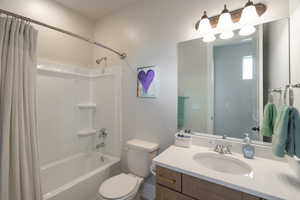 Full bathroom with shower / bath combo with shower curtain and vanity