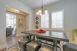 Dining room with light wood-type flooring and a chandelier
