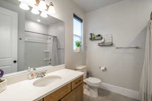 Full bathroom featuring vanity, curtained shower, and light tile patterned flooring