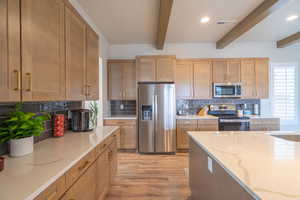 Kitchen featuring stainless steel appliances, tasteful backsplash, light stone countertops, light wood finished floors, and recessed lighting