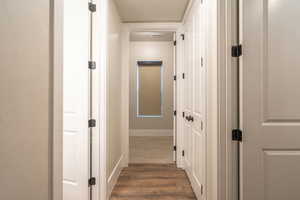 Corridor featuring dark wood-style floors and baseboards