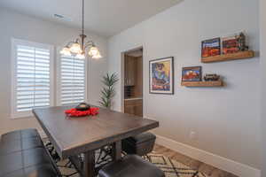 Dining area featuring wood finished floors and a chandelier
