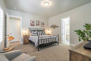 Bedroom with carpet and connected bathroom
