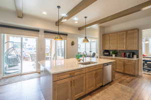 Kitchen with hanging light fixtures, dark wood-type flooring, brown cabinets, light stone counters, and stainless steel dishwasher