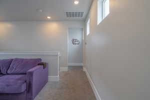 Hall featuring light colored carpet, an upstairs landing, and recessed lighting