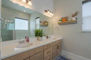 Bathroom featuring double vanity and a shower stall
