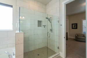 Bathroom featuring a shower stall, a garden tub, and carpet floors