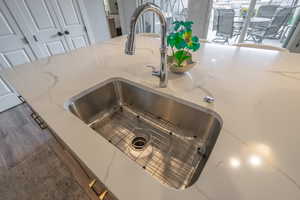 Kitchen view of light stone counters and wood finished floors