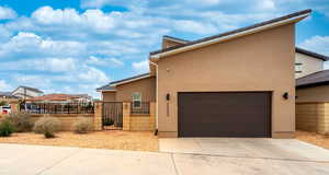 View of front of home with a fenced front yard, a gate, stucco siding, and concrete driveway