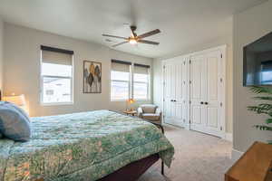 Bedroom featuring carpet flooring, ceiling fan, multiple closets, and a textured ceiling