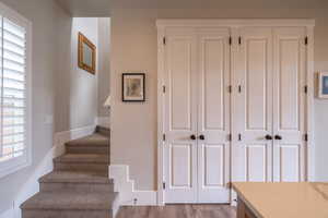 Stairs featuring wood finished floors and baseboards