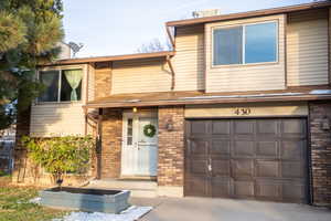 View of front of property featuring brick siding, an attached garage, and concrete driveway