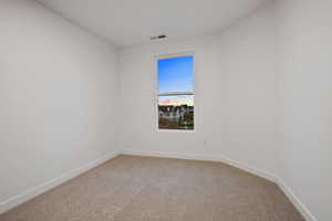 Spare room with light colored carpet and baseboards