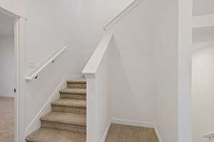 Stairs with carpet flooring and baseboards