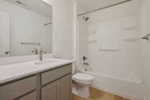 Bathroom with vanity,  shower combination, and light wood-style floors